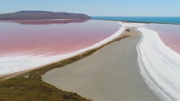 ピンクの湖と美しい風景のトップビュー。撃たれたピンクの水で自然湖の地球外奇跡。ピンクの湖、白い砂と水平線上の山々と美しい風景 — ストック動画