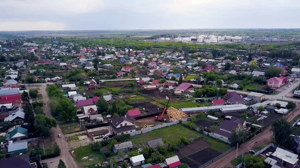 Blick von oben auf die Landstadt mit neuem Haus. Clip. Neues im Bau befindliches Holzhaus sticht auf Hintergrundpanorama des Hüttendorfes hervor — Stockfoto