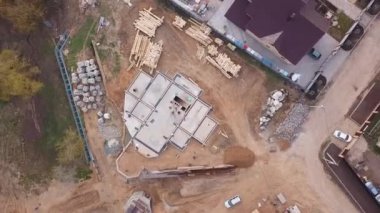 Inşaat malzemeleri ahşap panoları, kayalar, tuğla ve inşaat alanında çalışan ve beton dökme insanlar yukarıdan görünümü. Klip. Yeni bina yapım süreci