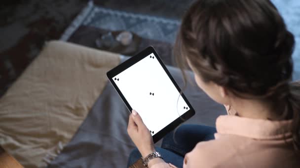 Close-up de jovem bonita mulher com cabelo castanho segurando iPad, digitando e deslizando na tela branca chave chroma em casa. Imagens de stock. Smartphone novo conceito de tecnologia — Vídeo de Stock