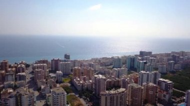 Deniz ve ufukta gökyüzü olan tatil köyü manzarası. Şarjör. Deniz ufkunun arka planında güneşli gökyüzü ile tatil köyü manzarası