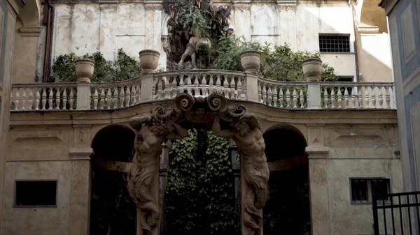 Arco con sculture di antico edificio. Azione. Arco incorniciato da statue conduce al giardino. Antica architettura europea con passaggi ad arco — Foto Stock