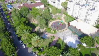Oyun parkı olan bir tatil köyü. Şarjör. Oyun parkı olan manzaralı güney tatil köyünün en üst manzarası. Yazın güney kentinde yüksek binaların yanındaki çocuk parkı