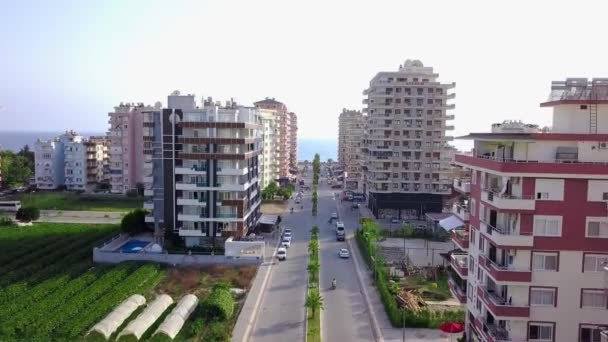 Denize çıkan şehir yolunun üst manzarası. Şarjör. Şehrin yüksek binalarının arasından geçen yol ufukta denize çıkar. Kasaba otellerinin deniz manzaralı düz yol manzarası — Stok video