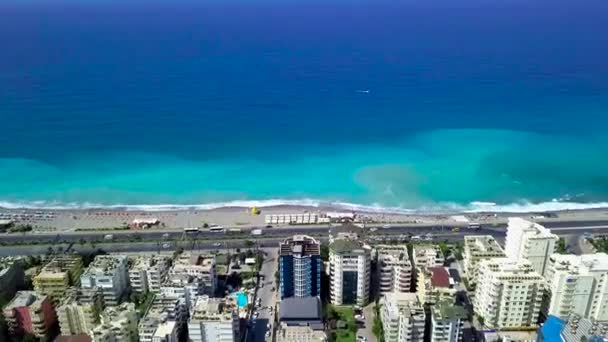 Vista dall'alto del bellissimo mare blu vicino alla costa della città turistica. Clip. Più bella acqua blu sulla costa resort con autostrada di passaggio. Migliore località estiva con alberghi vicino alla costa del mare cristallino — Video Stock