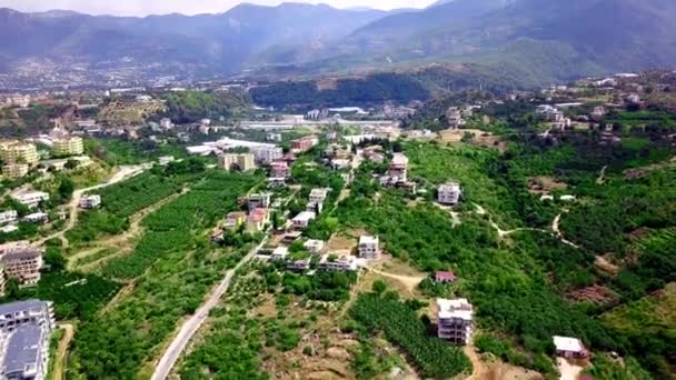 Vue sur la ville verte située dans les montagnes. Clip. La ville est entourée de végétation verte et d'arbres dans les montagnes. Resort ville est située sur un terrain montagneux inégal en été — Video