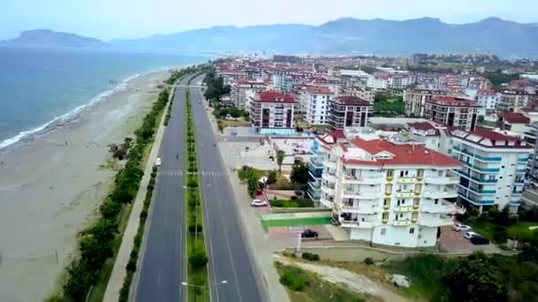 Vista superior de la carretera costera de la ciudad turística en el mar y las montañas. Clip. Hermosa pista que pasa a lo largo de la costa del sur ciudad turística — Vídeo de stock