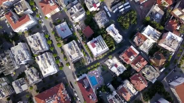 Top view of roofs and streets of city in summer. Clip. Beautiful southern city with orange roofs, high-rise buildings and green vegetation. Resort town for summer holidays — Stock Video