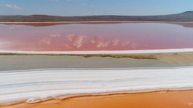Pembe göl manzaralı güzel bir manzara. Vuruldu. Pembe suyla doğa gölünün dünya dışı mucizesi. Pembe gölü, beyaz kumu ve ufukta dağları olan güzel bir manzara.