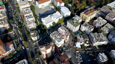 Yazın çatıların ve caddelerin en iyi manzarası. Şarjör. Turuncu çatıları, yüksek binaları ve yeşil bitkileri olan güzel bir güney şehri. Yaz tatili için tatil köyü