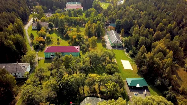 Top view of recreation center in forest with lake. Clip. Housing recreation in green forest near lake for country holiday. Forest recreation center for recreation near nature — Stock Photo, Image