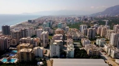 Deniz ve dağların arka planındaki sahil tatil beldeleri. Şarjör. Deniz manzaralı güzel bir yaz tatili manzarası. Tropikal iklimli sahil beldesinde yaz tatili