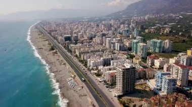 Dağların arkasındaki deniz manzaralı güzel büyük şehir manzarası. Şarjör. Mavi deniz ve dağ manzarası üzerinde yer alan güney tatil köyünün panoraması