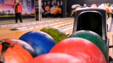 Bir bovling kulübünde bowling oynarken topu atmadan önce topu tutan adam için yakın çekim. Medya. Spor ve eğlence konsepti, raftan top alan adam..