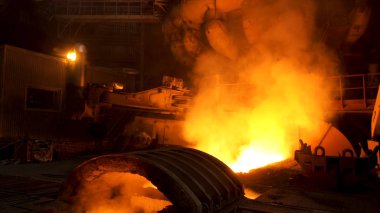 Eriyen metal ve yükselen dumanla elektrikli fırına yakın durun. Stok görüntüleri. Metalürji fabrikası, dökümhanede çelik üretimi, ağır metalurji konsepti..