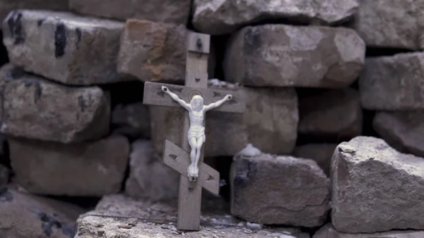 Cierre para la cruz de madera con Jesús crucificado sobre fondo de ladrillos de piedra, Biblia y concepto de religión. Filmación. Atributo religioso de la iglesia, simbolismo cristiano . —  Fotos de Stock