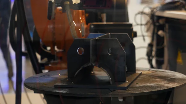 A amostra do braço do robô durante o processo de soldagem, trabalho automático, tecnologia e conceito industrial. Mídia. Procedimento de soldagem automatizado com muitos brilhos . — Fotografia de Stock