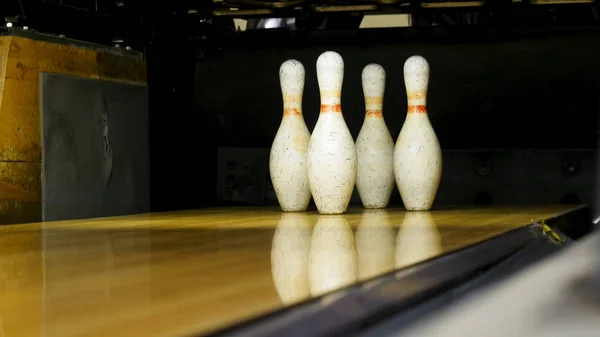 Palla verde non riesce a colpire i birilli sul campo di gioco, concetto di attività. I media. Chiudere per diversi vecchi spilli bianchi in piedi sul vicolo di legno durante il gioco . — Foto Stock