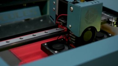 Kırmızı plastik malzemeden, modern mühendislik konseptinden bir figür elde etmek için 3D yazıcıya yaklaşın. Medya. Yenilikçi teknolojilerin sergilenmesi.