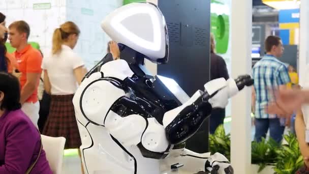 Gran robot divertido con grandes ojos azules sonriendo y hablando, mostrando emociones, concepto de tecnologías modernas. Medios. Cara robot amigable pantalla en la exposición científica . — Vídeos de Stock