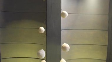 Tavandan sarkan beyaz alçı balonlarla dekore edilmiş geniş kısa panellerden oluşan yeşil tavan, iç tasarım konsepti. - Sanat. Yeşil paneller ve beyaz toplar, kıç görünümü.