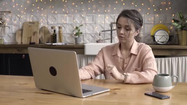 Vuxen mörkhårig kvinna som arbetar på laptop i köket hemma, tidsfördröjning effekt. Stock film. Modern teknik och inredningskoncept, kvinnliga skriva ett meddelande. — Stockvideo