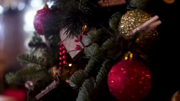 Uzavřete vánoční hračky na zeleném stromě s leskavýma girlandou. Rámeček. Smrková větev zdobená novými ročními hračkami, barevným míčkem a postavami, veselý vánoční koncept.