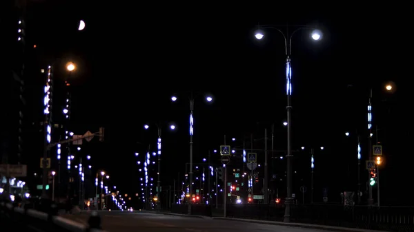 Leere Wohnstraße am späten Abend mit Straßenschildern und Laternen vor schwarzem Himmel. Archivmaterial. Nacht städtische Straße beleuchtet von Neonlichtern. — Stockfoto