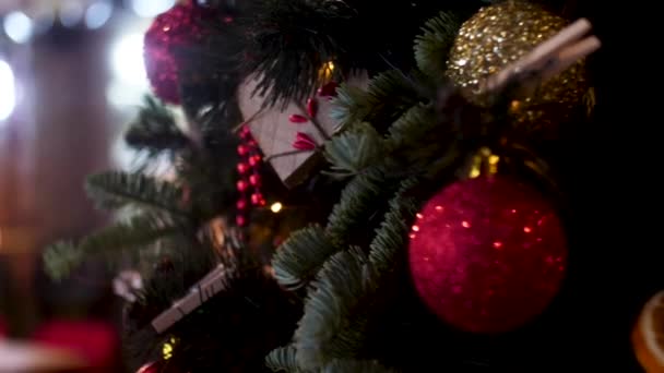 Nové roky míčky a Garland na rozmazané pozadí, koncept svátků. Rámeček. Vánoční skladba borového stromu, zlaté a červené vánoční kuličky, červené bobule. — Stock video