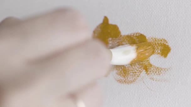 Sluiten voor de kunstenaar borstel en met de hand tekenen met bruine kleur. Actie. Vrouw de hand houden van de borstel en beginnen te maken van een kunstwerk op witte doek achtergrond, olieverf. — Stockvideo