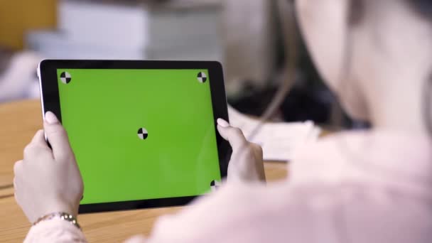 Вид спереду на брюнетку з використанням планшета з зеленим екраном, концепція сучасних технологій. Стокові кадри. Жінка тримає ipad з хроматиєю і читає щось . — стокове відео