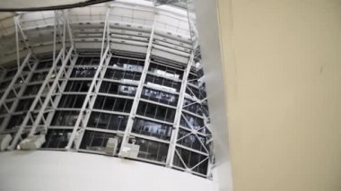 Yeni spor stadyumunun cam ve beyaz metalinden yapılmış beyaz yapının alt görüntüsü, mimari konsept. Başla. Spor salonunun duvarına bak..