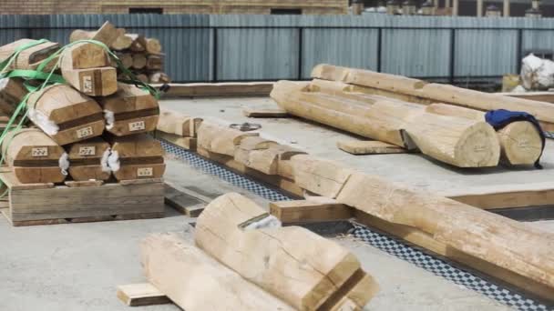 Site de construction avec de nombreuses poutres en bois couchées sur la fondation en béton. Clip. Cadres en bois placés sur la base en béton pour la construction d'une maison . — Video