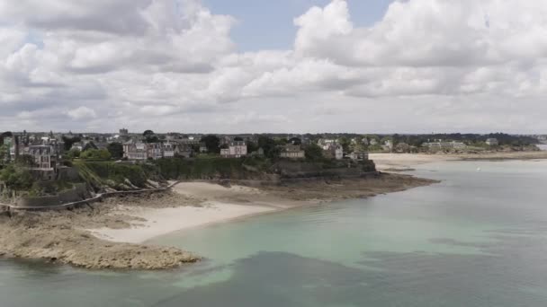 Aéreo para a costa de esmeralda localizada na cidade de Dinard, Bretanha, França. Acção. Paisagem de tirar o fôlego com costa do mar e casas bonitos no fundo azul céu nublado . — Vídeo de Stock