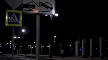 Gecenin ilerleyen saatlerinde boş bir yerleşim yeri ve kara gökyüzü arka planında trafik lambaları. Stok görüntüleri. Gece şehir caddesi neon ışıklarıyla aydınlanıyor..