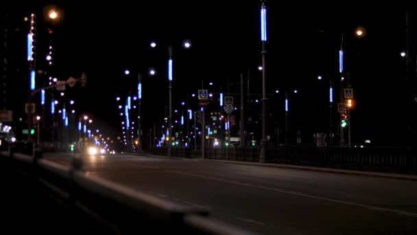 道路上的夜车，孤独的汽车沿着路灯行驶。 库存录像。 夜市道路，街道灯火通明，车辆在漆黑的天空背景下行驶. — 图库视频影像