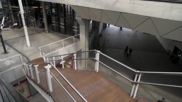 Vista dall'alto di scale in legno all'interno di un moderno edificio della stazione, trasporto e concetto di infrastruttura. Filmati delle scorte. Interno dell'edificio pubblico con scale, ampio salone e sottopassaggio . — Video Stock