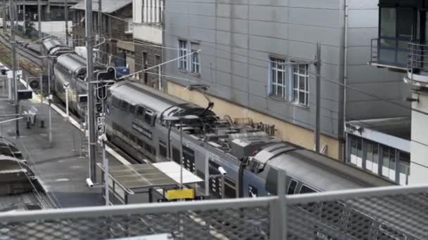 Tren de llegada a una estación de tren, Rennes, Francia. Imágenes de archivo. El tren que llega a la plataforma de la estación de tren, la infraestructura ferroviaria . — Vídeos de Stock