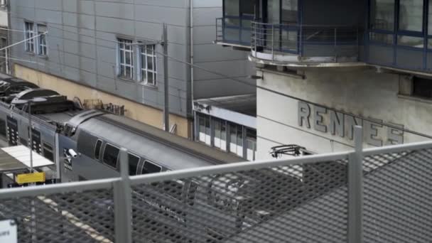 Tren de llegada a una estación de tren, Rennes, Francia. Imágenes de archivo. El tren que llega a la plataforma de la estación de tren, la infraestructura ferroviaria . — Vídeo de stock