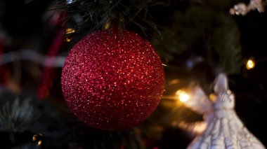 Parlayan çelenk ile yeşil ağaç üzerinde Noel oyuncakları için kapatın. Çerçeve. Ladin ağaç dalı yeni yıl oyuncakları, renkli topları ve figürleri, mutlu noel konsepti ile dekore.