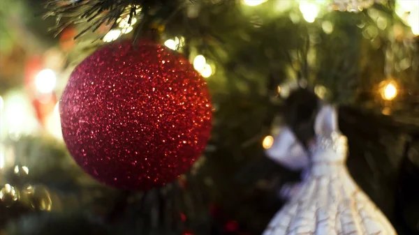 Decorated Christmas tree on blurred, sparkling and fairy background, merry christmas and happy new year concept. Frame. Close up for red shining ball and illuminated garland with flashlights. — Stock Photo, Image