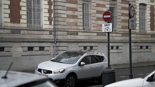 A residential street with parked cars and road signs on brick building background, city traffic concept. Stock footage. Side view of a white beautiful car parked in the street. — Stock Photo, Image