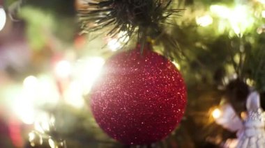 Bulanık, ışıl ışıl ve peri geçmişiyle süslenmiş Noel ağacı, mutlu noeller ve mutlu yeni yıl konsepti. Çerçeve. Kırmızı parlayan top ve fenerlerle aydınlatılmış çelenk için yakın..