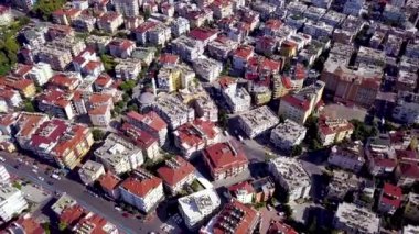 Kırmızı çatıları olan yüksek binaların üst manzarası. Şarjör. Şehrin manzarasında kırmızı çatıları olan güzel evler birbirine yakındır.