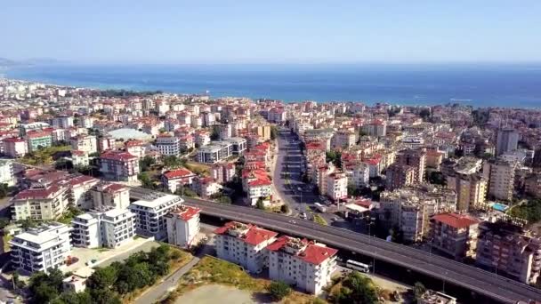 Vista superiore della città resort sulla costa di montagna vicino al mare blu. Clip. Bellissimo panorama della città situata sulla costa del mare. Vista della città dall'orizzonte del mare — Video Stock