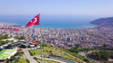 Şehir ve denizin arka planında dağdaki Türk bayraklarının en üst görüntüsü. Şarjör. Sahildeki dağlık bölgede bulunan Türk tatil beldesi