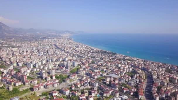 Vista dall'alto della città turistica situata sulla costa. Clip. Panorama di città su costa di montagna di mare su sfondo di bel cielo. Paradise resort con climi tropicali via mare — Video Stock