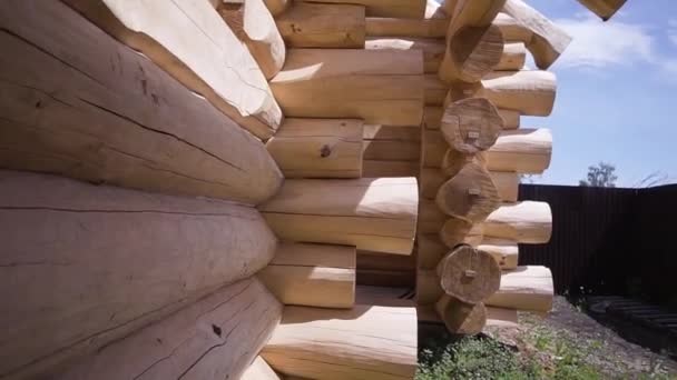 Construction of log house. Clip. Wall of wooden house of chopped logs in process of construction. Outer part of wall with protruding logs of wooden country house — Stock Footage Construction of log house. Clip. Wall of wooden house of chopped logs in process of construction. Outer part of wall with protruding logs of wooden country house Royalty Free Stock Footage