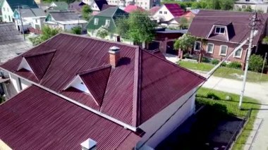 Kır evinin çatısının üst manzarası. Stok görüntüleri. Köyde çok güzel yeni bir ev var. Çatı kestanesi veya koyu kırmızı pahalı ve güzel görünüyor.