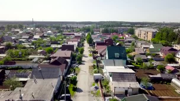 Vista superior da estrada em linha reta na aldeia com casas. Imagens de stock. Cidade industrial velha com casas particulares no fundo da floresta e horizonte — Vídeo de Stock